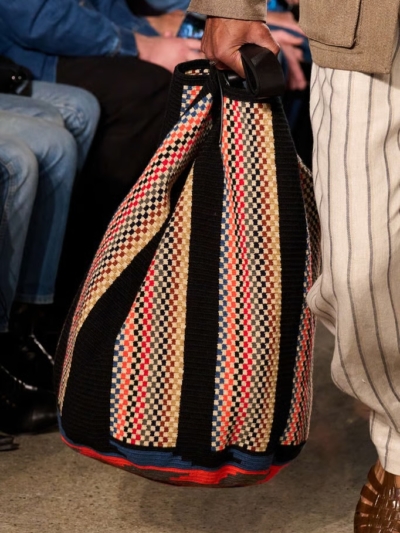 Guanabana woven bag showcased on runway during fashion show, styled with neutral tones and contemporary menswear look
