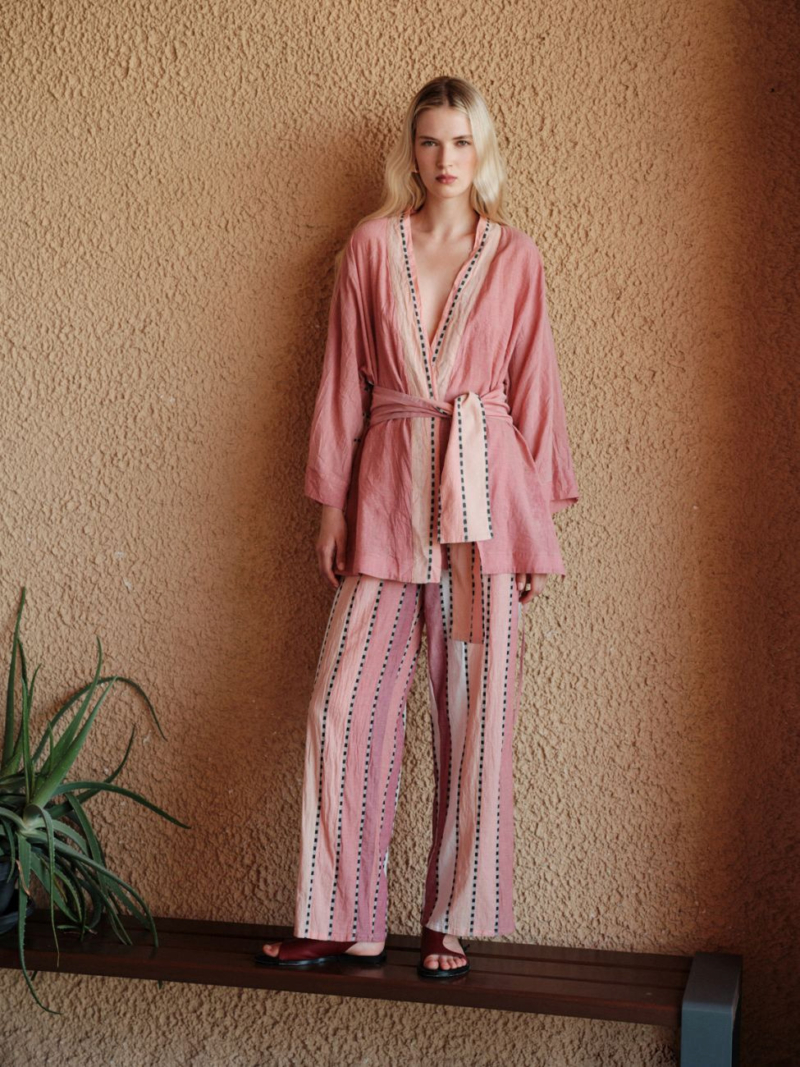 Relaxed kimono by Devotion Twins in a soft pink tone, featuring contrast trim, wide sleeves, and a self-tie belt for effortless resort-inspired styling.