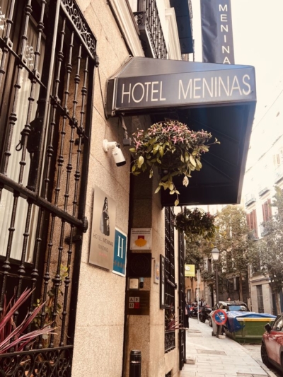 Atmospheric street in Madrid with neoclassical buildings and warmly lit restaurants, captured during a sourcing trip for Guanabana products for The Little Store in Pythagoreio, Samos